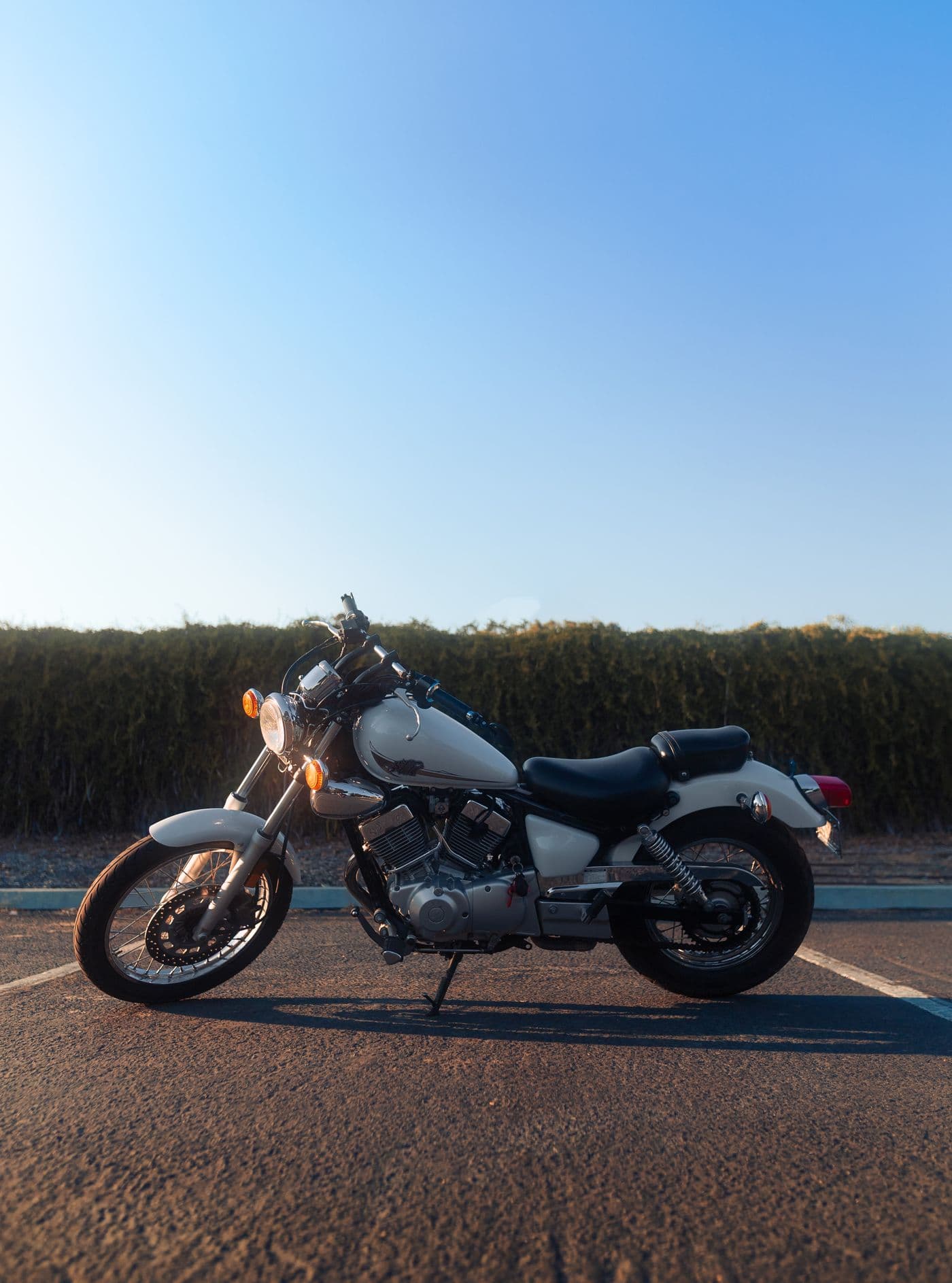 Moto custom clara de perfil bajo un cielo despejado